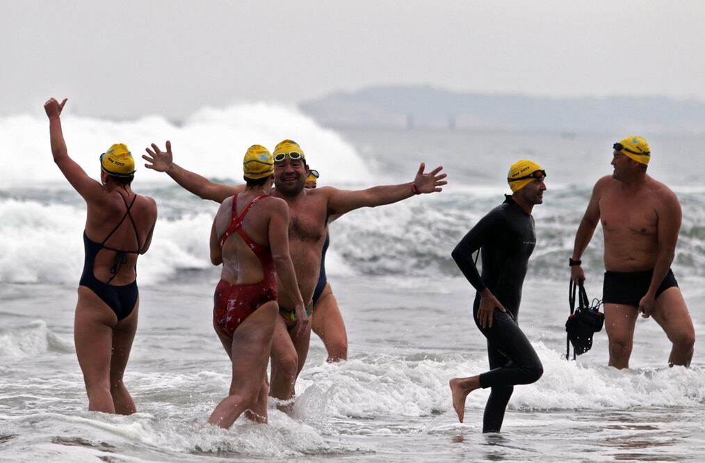 Nadadores participantes del Cruce Panamericano Colibrí celebran a su llegada a una playa de Tijuana, tras nadar desde Imperial Beach, en San Diego, California. Foto: AFP