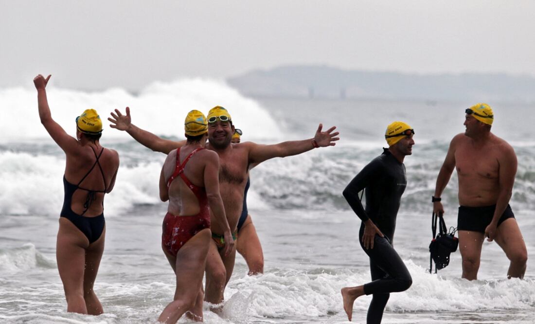 Nadadores participantes del Cruce Panamericano Colibrí celebran a su llegada a una playa de Tijuana, tras nadar desde Imperial Beach, en San Diego, California. Foto: AFP