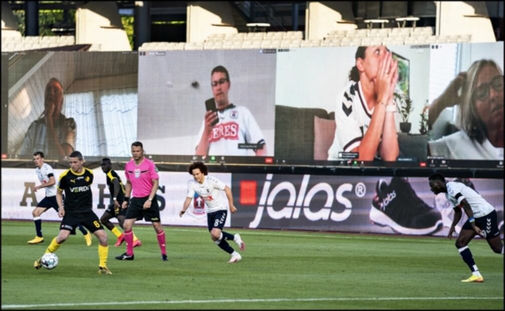 Jugadores ven a los aficionados en pantallas durante partido