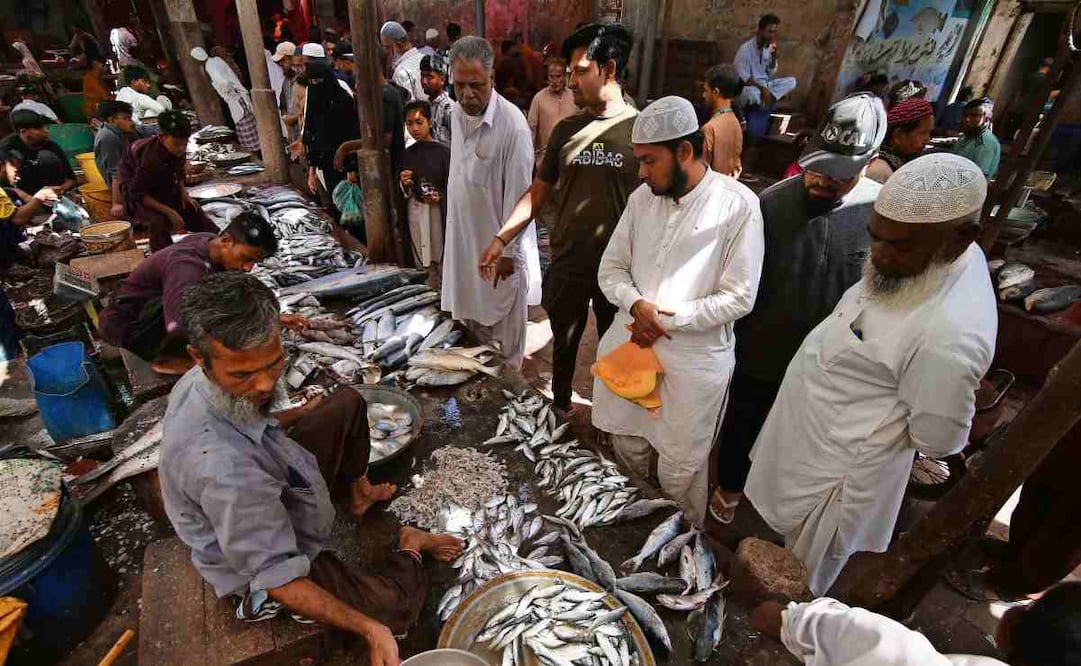 Clientes observan los mariscos antes del Día Mundial de la Alimentación en un mercado local de Karachi, Paquistán. Foto: Rehan Khan / EFE
