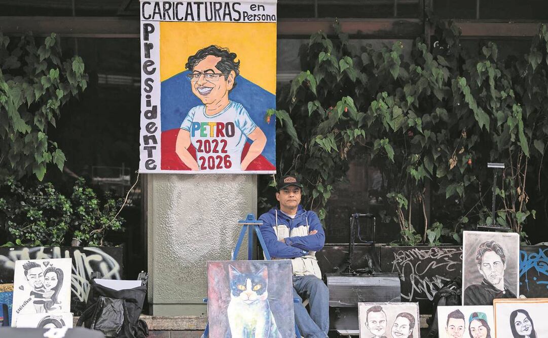 Un artista, con una caricatura del candidato presidencial izquierdista Gustavo Petro, espera clientes en la capital colombiana. Foto: Yuri Cortez/AFP