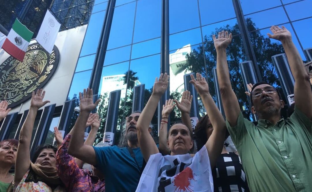 En la reja de la entrada de la PGR, los participantes levantaron las manos en señal de entrega. /Dennis A. García - EL UNIVERSAL