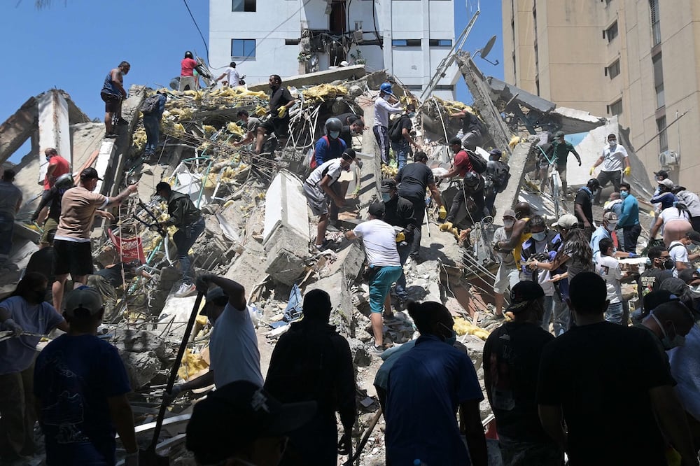 Ciudadanos buscan sobrevivientes entre los escombros de un edificio colapsado en Cali, Colombia. FOTO: JOAQUÍN SARMIENTO. AFP