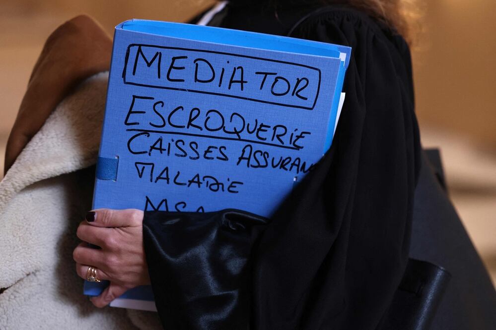 Una abogada sostiene un expediente en el que se lee "Mediator : fraude, seguro de enfermedad" a su llegada a la apertura del juicio en apelación de la empresa farmacéutica Laboratorios Servier. FOTO: THOMAS SAMSON. AFP