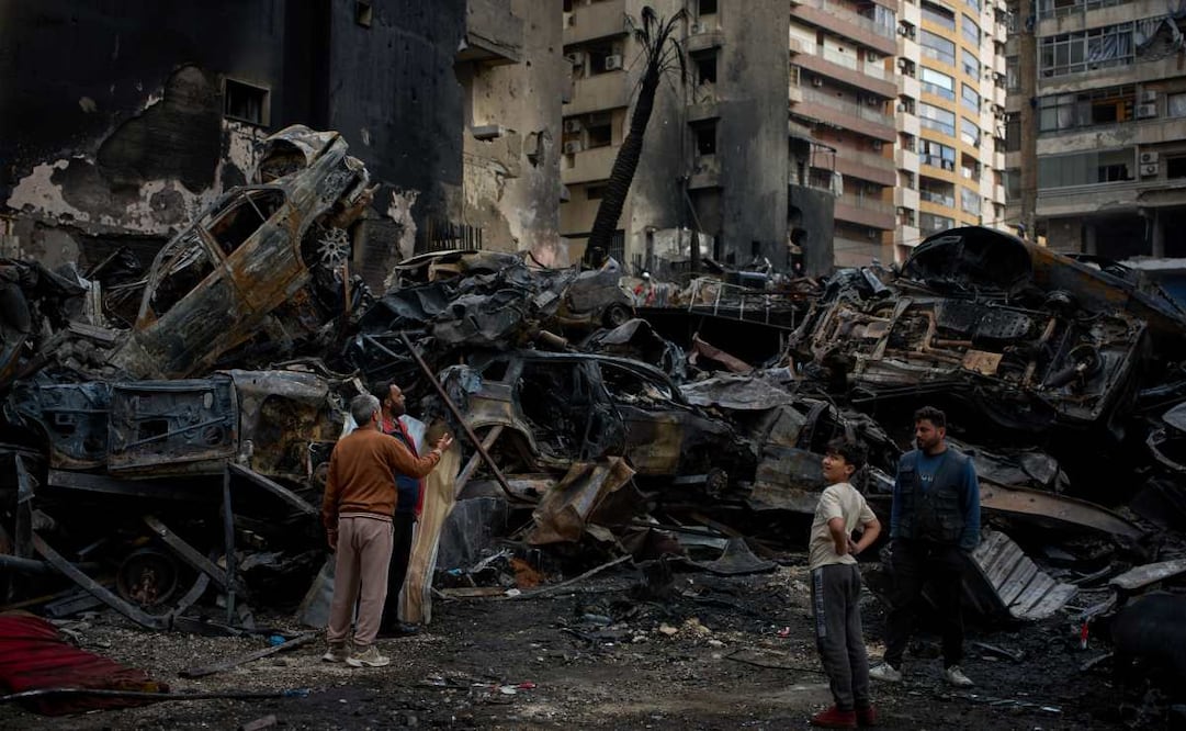 Personas se reúnen el viernes 10 de abril de 2026 cerca de coches y edificios calcinados, en el lugar donde se produjo el ataque aéreo israelí del miércoles, en Beirut, Líbano. Foto: AP