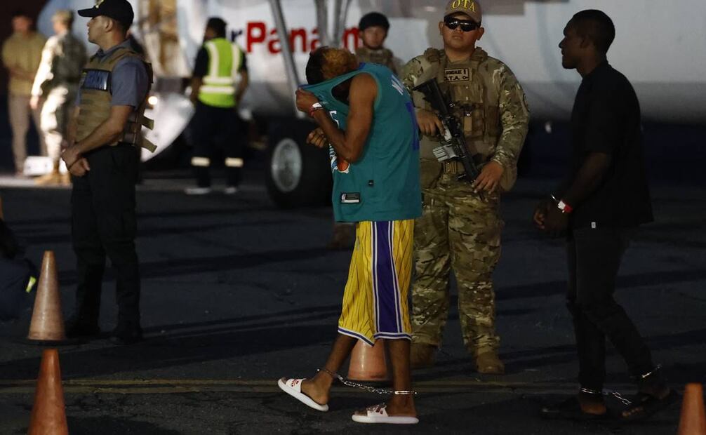 Un migrante camina frente a un avión antes de ser deportado a Colombia. Foto: EFE
