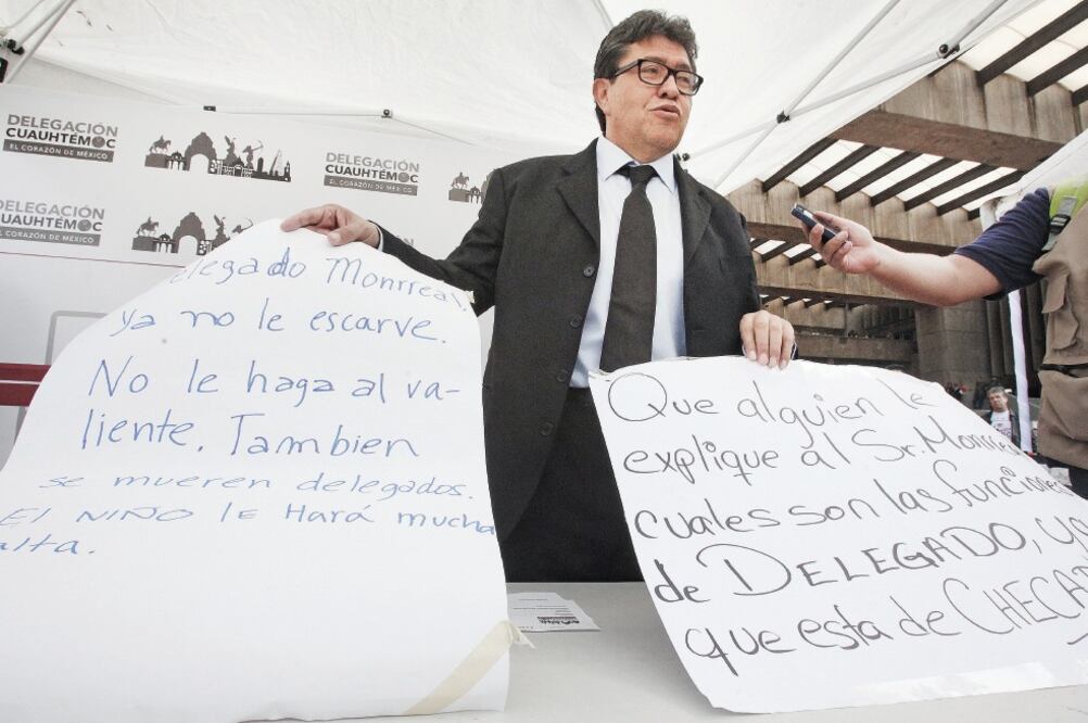 Ricardo Monreal presentó ayer los carteles que fueron encontrados en los muros de la sede delegacional, en donde se le exige dejar de “escarbar ” en los problemas de la demarcación y evitar andar de “checador ” (ADRIÁN HERNÁNDEZ. EL UNIVERSAL)
