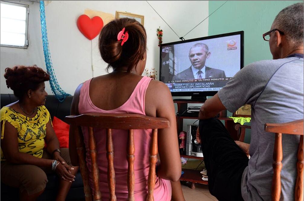 Cubanos escuchan el anuncio del presidente estadounidense, Barack Obama, sobre la reapertura de embajadas, ayer. Foto Xinhua