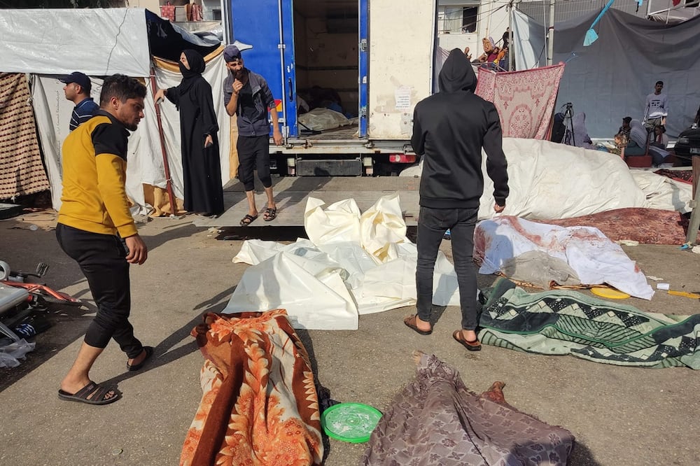 La gente revisa los cuerpos de las víctimas muertas en un presunto ataque israelí, mientras yacen en el suelo en las cercanías del complejo hospitalario Al-Shifa de la ciudad de Gaza. Foto: AFP