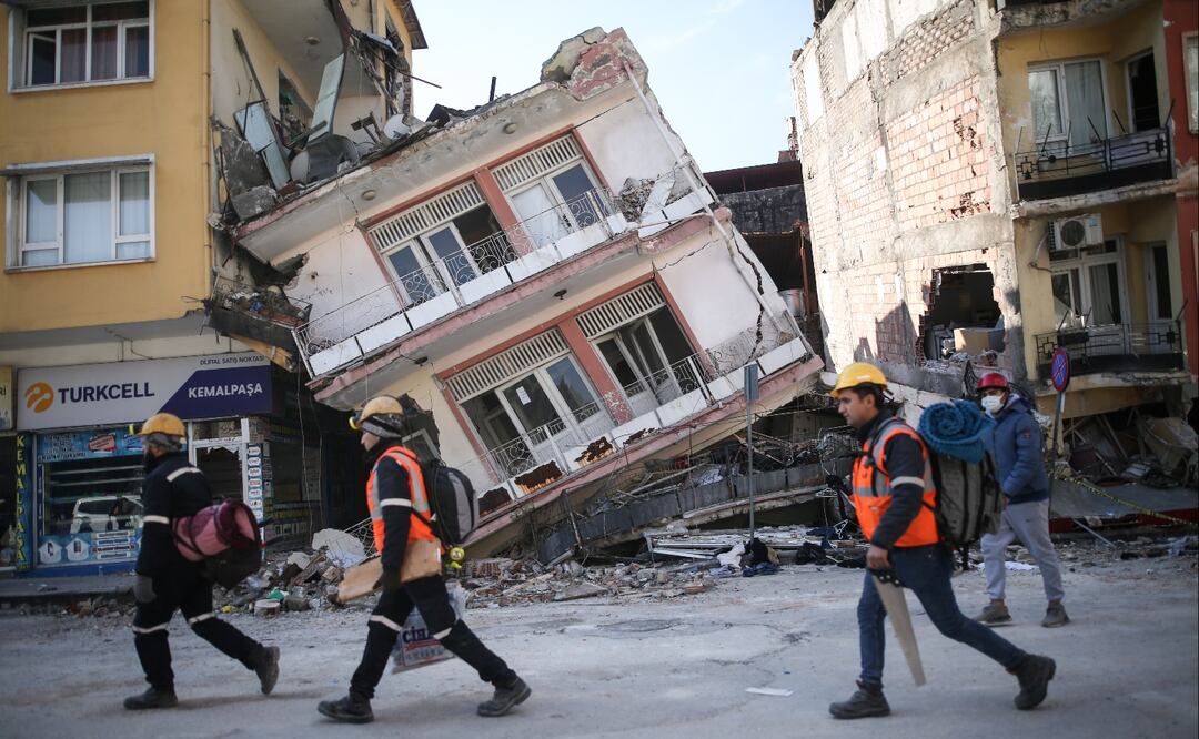 Los rescatistas caminan junto a los edificios derrumbados tras el poderoso terremoto en Hatay, sureste de Turquía. FOTO: EFE