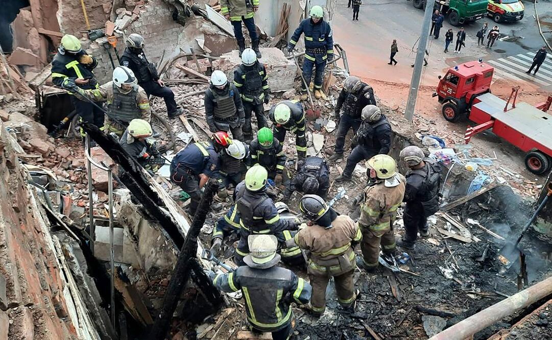 En esta imagen, distribuida por la Oficina de Prensa de la Policía de Ucrania, personal de emergencias busca posibles víctimas tras un ataque con un proyectil ruso que causó daños en un edificio de varias plantas en Járkiv, el 6 de octubre de 2023. Foto: AP