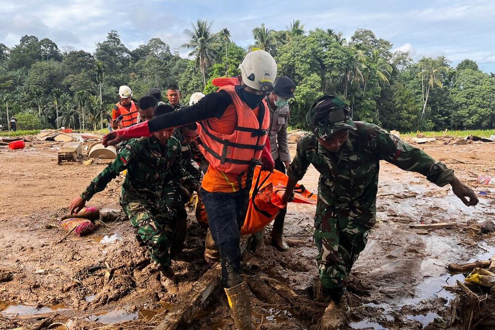 Rescatistas cargan el cuerpo de una víctima de las inundaciones en Agam, Sumatra Occidental, Indonesia, el domingo 30 de noviembre de 2025. FOTO: AP