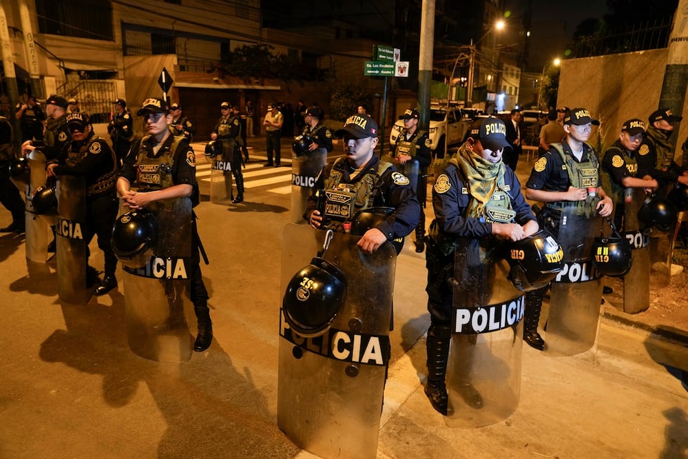 La policía vigila afuera de la casa de la presidenta Dina Boluarte durante una redada ordenada por la Fiscalía General destinada a incautar relojes Rolex como parte de una investigación preliminar sobre presunto enriquecimiento ilícito en Lima. Foto: AP