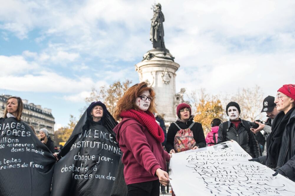 Activistas con un cartel que contiene los nombres de mujeres víctimas de la violencia doméstica se manifestaron ayer en París. (CHRISTOPHE PETIT TESSON. EFE)