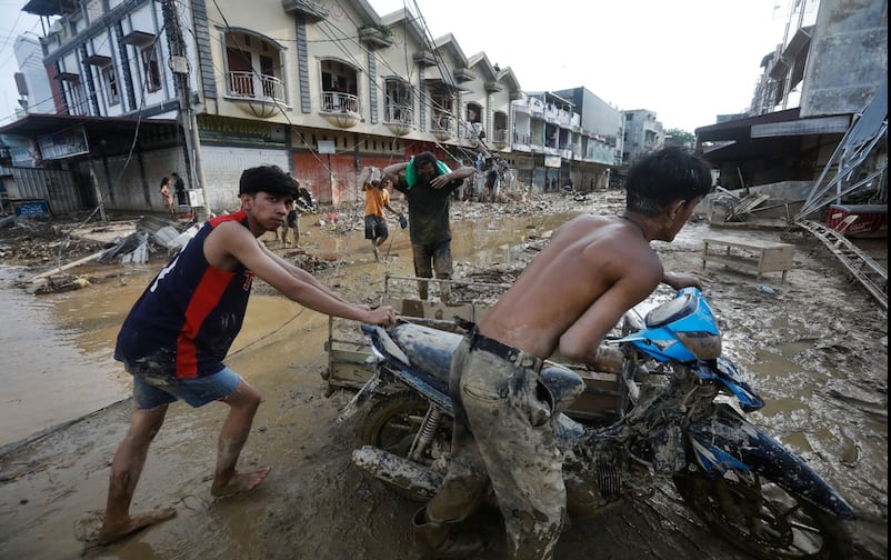 Jóvenes rescatan una motocicleta en una zona afectada por las inundaciones causadas por el paso de ciclones, en Aceh Tamiang, isla de Sumatra, Indonesia, el jueves 4 de diciembre de 2025. Foto: AP