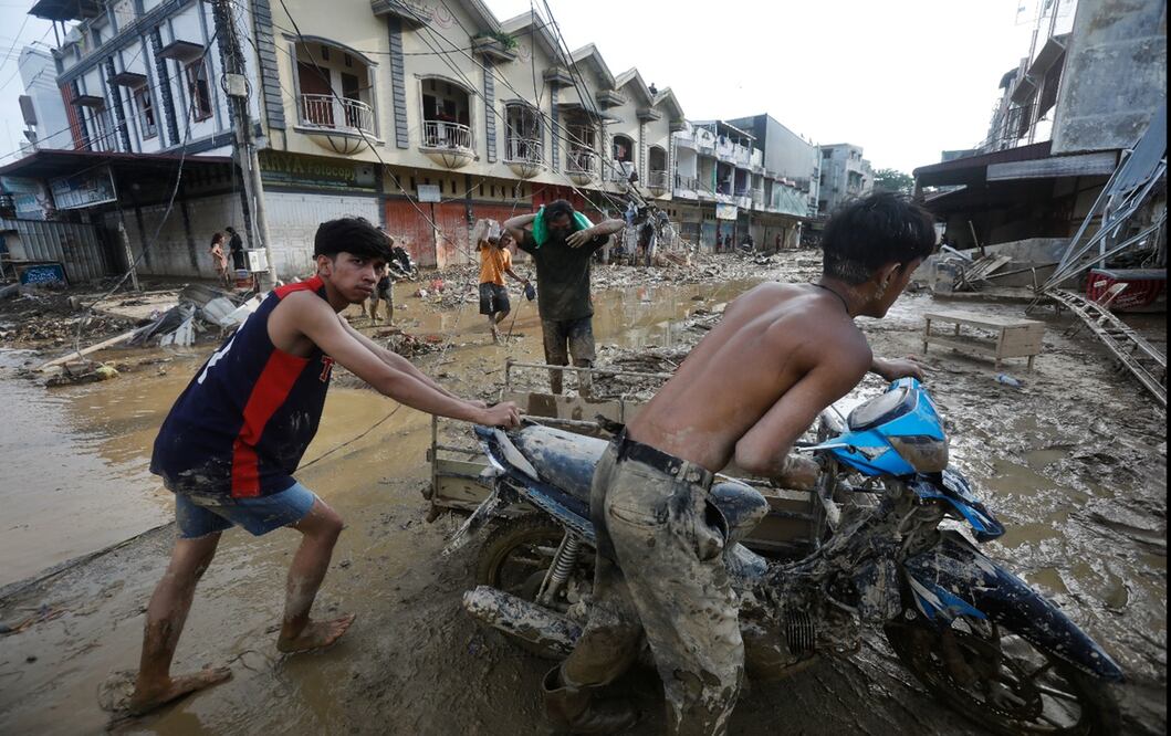 Jóvenes rescatan una motocicleta en una zona afectada por las inundaciones causadas por el paso de ciclones, en Aceh Tamiang, isla de Sumatra, Indonesia, el jueves 4 de diciembre de 2025. Foto: AP