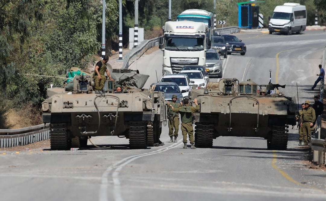 Soldados israelíes en vehículos blindados conducen por una calle cerca de la ciudad norteña de Kiryat Shmona, cerca de la frontera con el Líbano, el 13 de octubre de 2023. Foto: AFP