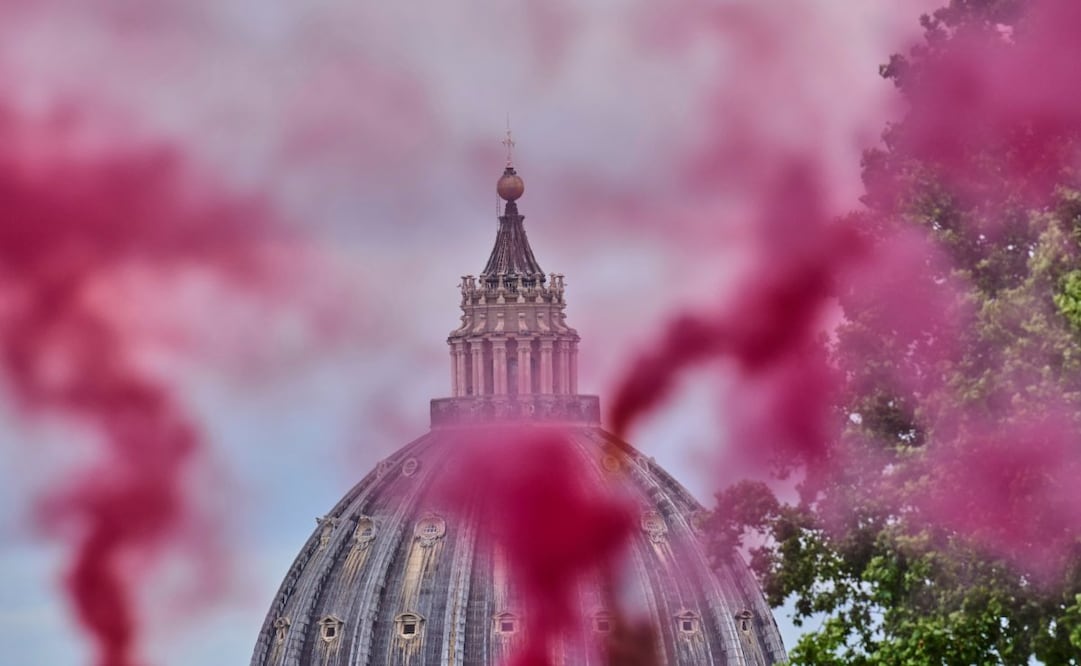 Una columna de humo rosa se eleva frente a la Cúpula de San Pedro durante una protesta de la Conferencia de Ordenación de Mujeres, que exige la plena igualdad de las mujeres en la Iglesia Católica, el primer día del cónclave para elegir al 267.º papa, en Roma, el miércoles 7 de mayo de 2025. Foto: AP