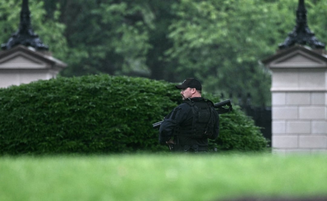 Un agente armado del Servicio Secreto patrulla inmediaciones de la Casa Blanca tras aparentes disparos (23/05/2026). Foto: AFP