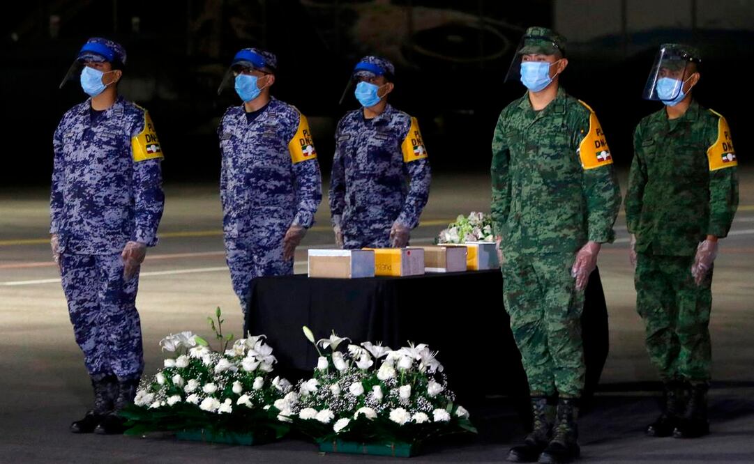 Miembros de las Fuerzas Armadas junto a urnas que contienen cenizas de mexicanos que murieron por COVID-19 en EU, luego de la repatriación de sus restos / Archivo. AFP
