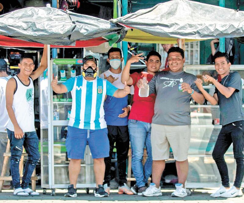 Vendedores ambulantes posan para una fotografía mostrando las medidas de higiene que utilizan, en Managua. Foto: JORGE TORRES. EFE
