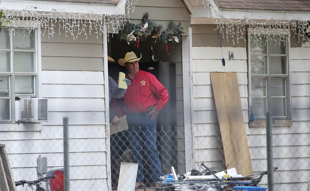 El alguacil del condado de San Jacinto, Greg Capers, habla con investigadores en la escena del crimen donde cinco personas fueron asesinadas. FOTO: AP