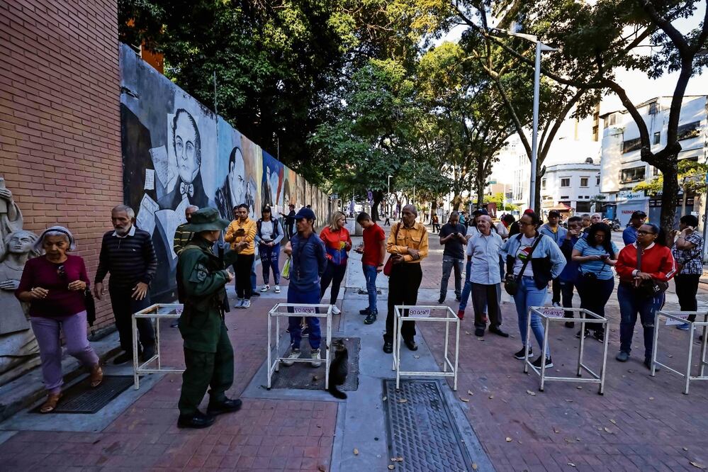 Votantes esperan para ingresar a un centro de votación del referéndum sobre la disputa con Guyana, en Caracas. Foto: EFE