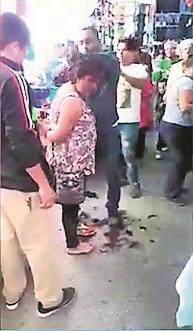 La grabación muestra a un hombre que sujeta a la señora, otro le quita su bolsa y uno más le corta el pelo y le propina una bofetada (TOMADA DE INTERNET)