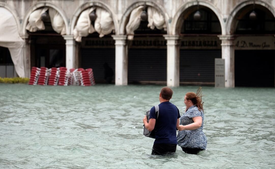 Una pareja camina sobre Saint Mark Square en Venecia tras las fuertes lluvias que provocaron inundaciones  (Fotos: Reuters)
