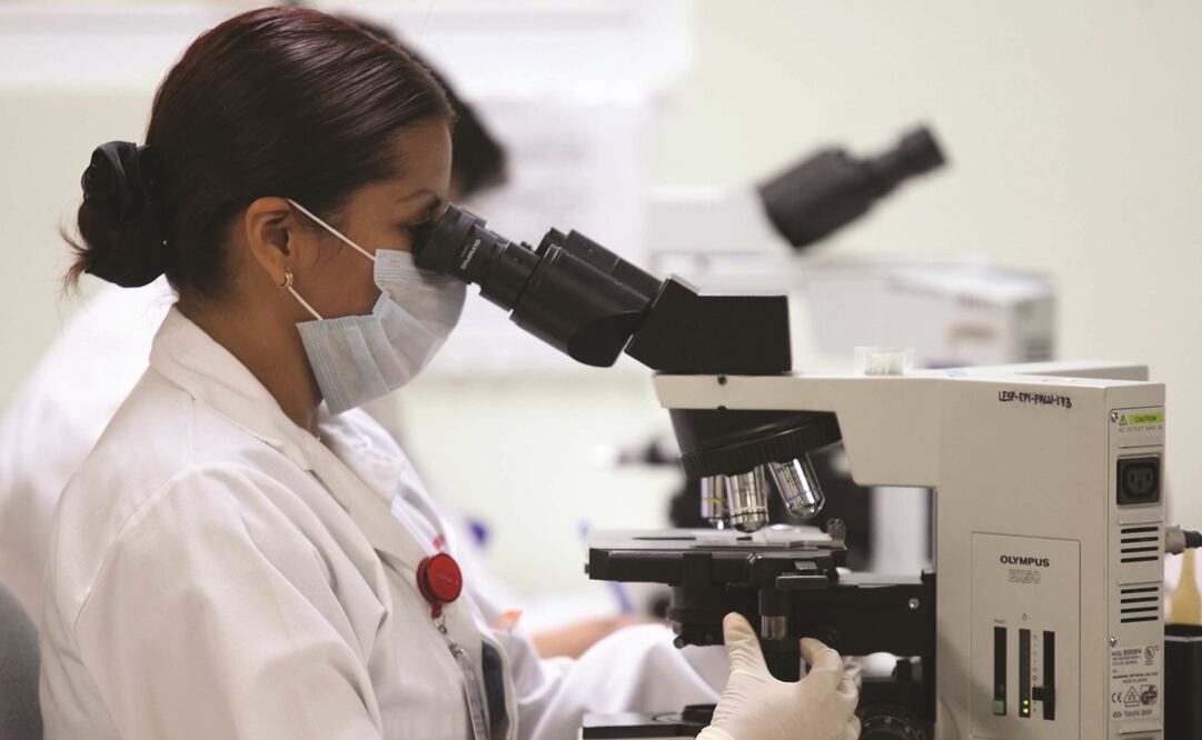 Científica viendo a través de un microscopio. Foto: Archivo