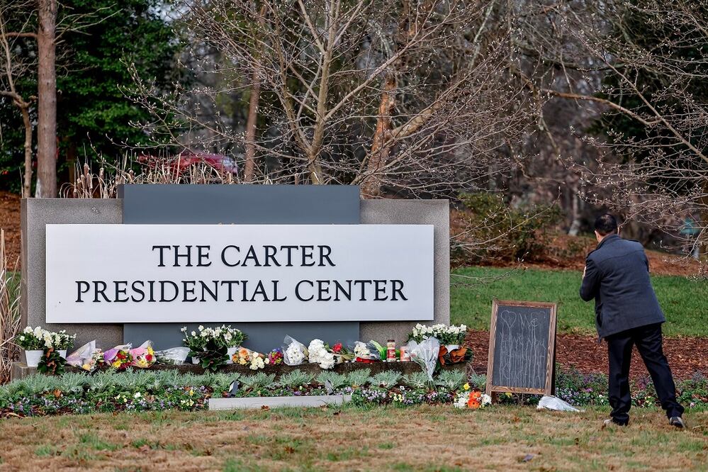 Atlanta. Un hombre observa las flores colocadas en el Centro Presidencial Carter para homenajear al expresidente estadounidense Jimmy Carter, en Atlanta, Georgia. FOTO: EFE