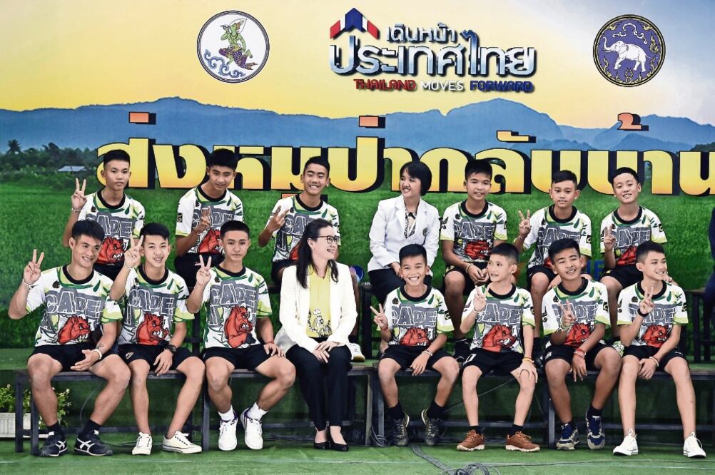 Doce niños tailandeses y su entrenador, rescatados de una cueva inundada, asistieron a una conferencia de prensa ayer luego de ser dados de alta del hospital (LILLIAN SUWANRUMPHA. AFP)