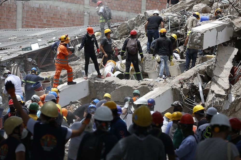 Un integrante de la brigada mexicana de socorristas Los Topos Azteca y rescatistas de Colombia participan en una jornada de búsqueda y rescate entre los escombros de un edificio en Cali. FOTO: ERNESTO GUZMÁN. EFE