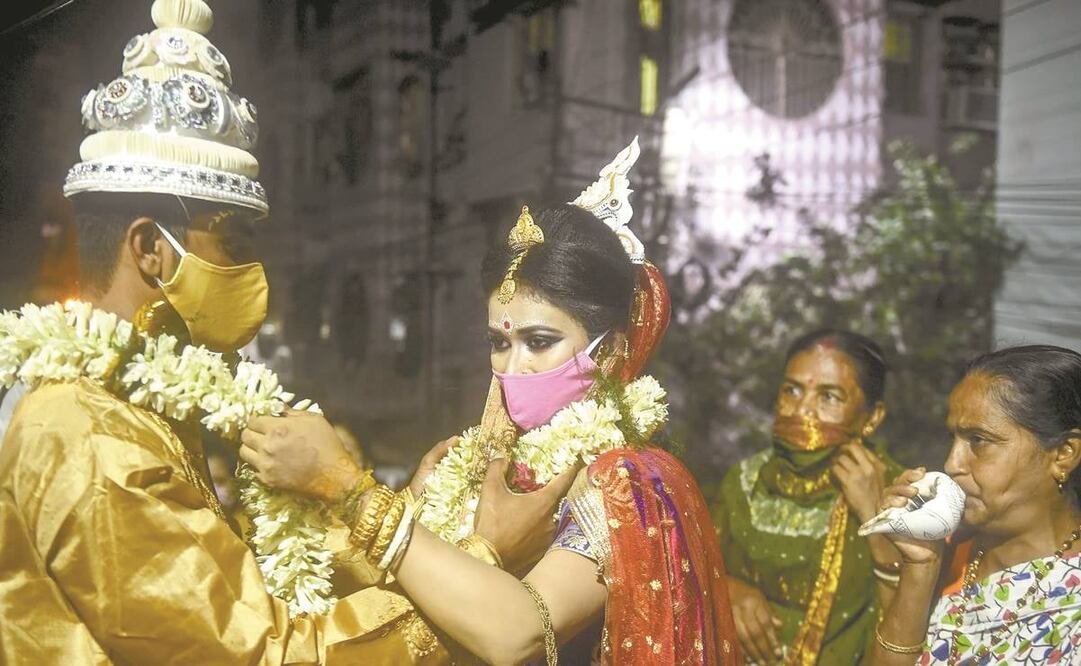 Una boda en Calcuta, India. El segundo país más poblado del mundo, con mil 300 millones de habitantes, supera el millón y medio de casos de SARS-CoV-2; de ellos, 500 mil desde el pasado 17 de julio. La cifra de decesos rebasa los 64 mil. Foto: AFP