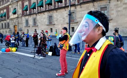 Payasos y cirqueros hacen malabares frente a Palacio Nacional