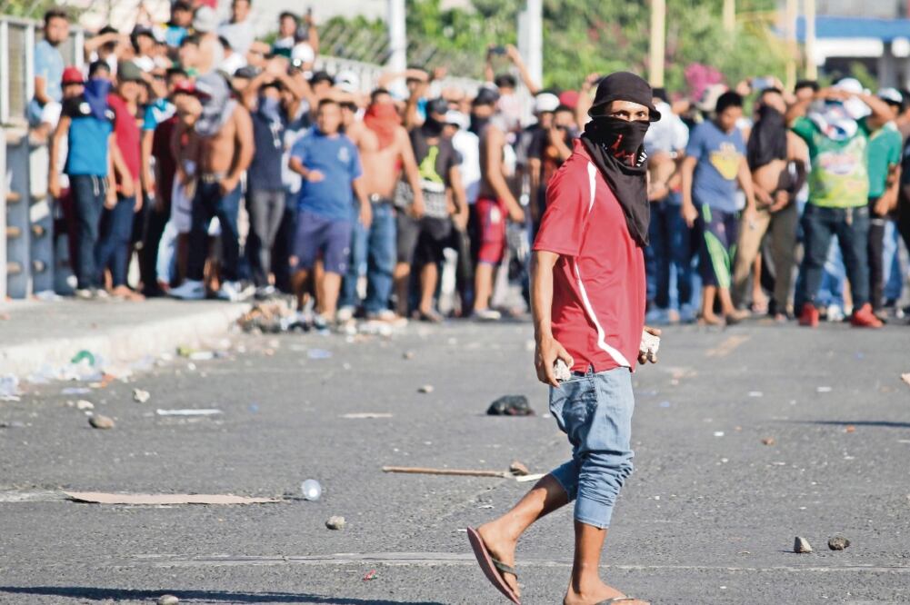Con palos y piedras, los guatemaltecos intimidaron a los migrantes centroamericanos, quienes se vieron forzados a dirigirse hacia el Puente Internacional Rodolfo Robles. (LUIS VILLALOBOS. EFE)