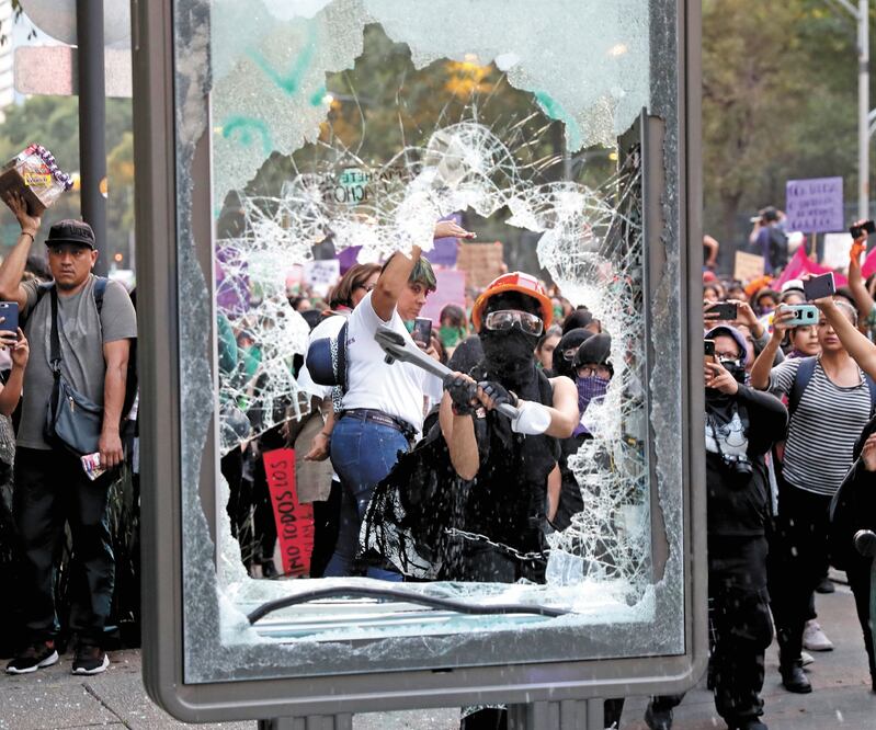 Durante la protesta un grupo de encapuchadas causaron daños al mobiliario urbano, como estaciones del Metrobús, y lanzaron pintura a hombres y policías. VALENTE ROSAS. EL UNIVERSAL
