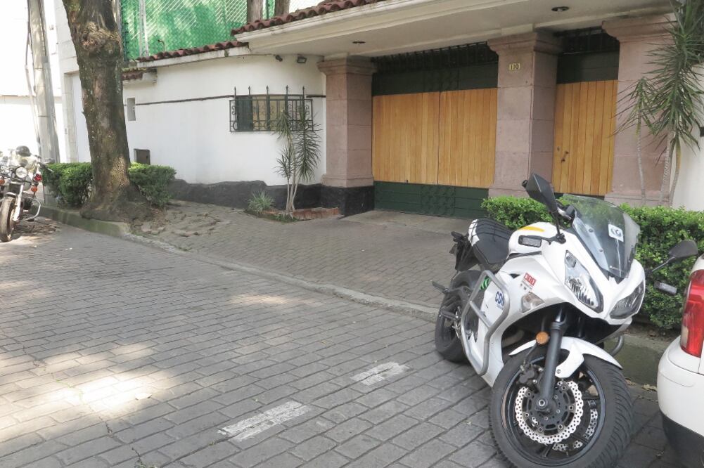 Dos escoltas con traje, dos motocicletas y una patrulla estacionadas, resguardan el frente del domicilio del cardenal Norberto Rivera; además, una camioneta de la policía hace rondines constantes por la zona. Foto: LUIS CORTÉS. EL UNIVERSAL