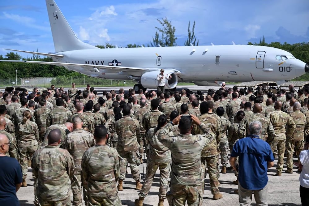 Fotografía cedida por la Gobernación de Puerto Rico donde aparece el secretario de Guerra de Estados Unidos, Pete Hegseth (centro), hablando con militares en la Base Aérea Muñiz, antes de partir al buque anfibio Iwo Jima, en El Caribe. FOTO: EFE