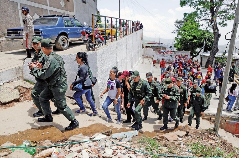 Miembros de las Fuerzas Armadas, durante su participación ayer en los ejercicios militares en el barrio de San Pedro, en Caracas (MARCO BELLO. REUTERS)