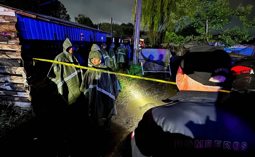 Bomberos y policías inspeccionan el área luego de que un incendio arrasara un asentamiento habitacional matando a 14 migrantes venezolanos, entre ellos ocho niños, en el campamento Los Pirquenes, en el sector Cerro Obligado de la comuna de Coronel, Región del Bío Bío, Chile, el 6 de noviembre / Foto: AFP