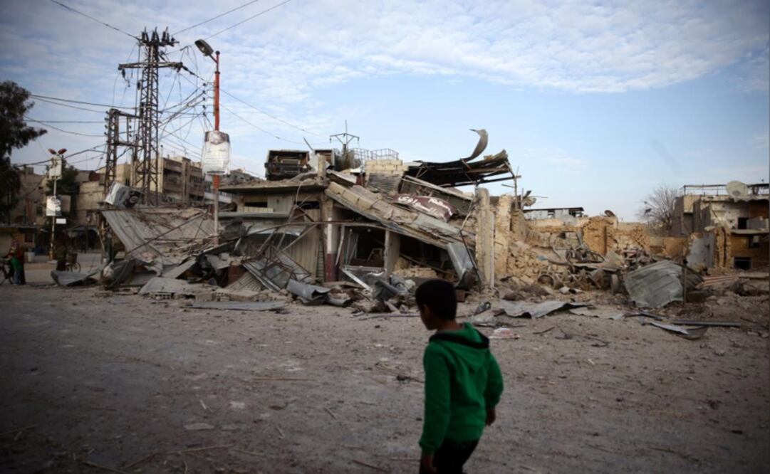 A child walks near damaged buildings in the besieged town of Douma, Eastern Ghouta, Damascus - Photo: Bassam Khabieh/ Reuters