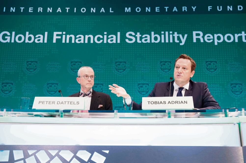 Tobias Adrian, consejero financiero y director del Departamento de Asuntos Monetarios y Mercados de Capital del FMI (der.), y Peter Dattels, subdirector del Departamento de Asuntos Financieros, al presentar el informe en Washington. (STEPHEN JAFFE. AFP)