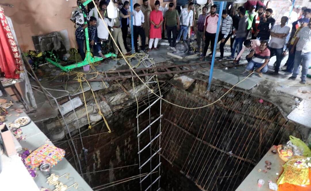 Gente rodea una estructura construida sobre el pozo de un templo antiguo que se derrumbó el jueves cuando una gran cantidad de fieles acudieron al festival hindú de Ram Navami en Indore, India,. Unas 35 personas cayeron al pozo al derrumbarse la estructura y quedaron cubiertas por los escombros, dijo el jefe de policía Makrand Deoskar. Foto: AP