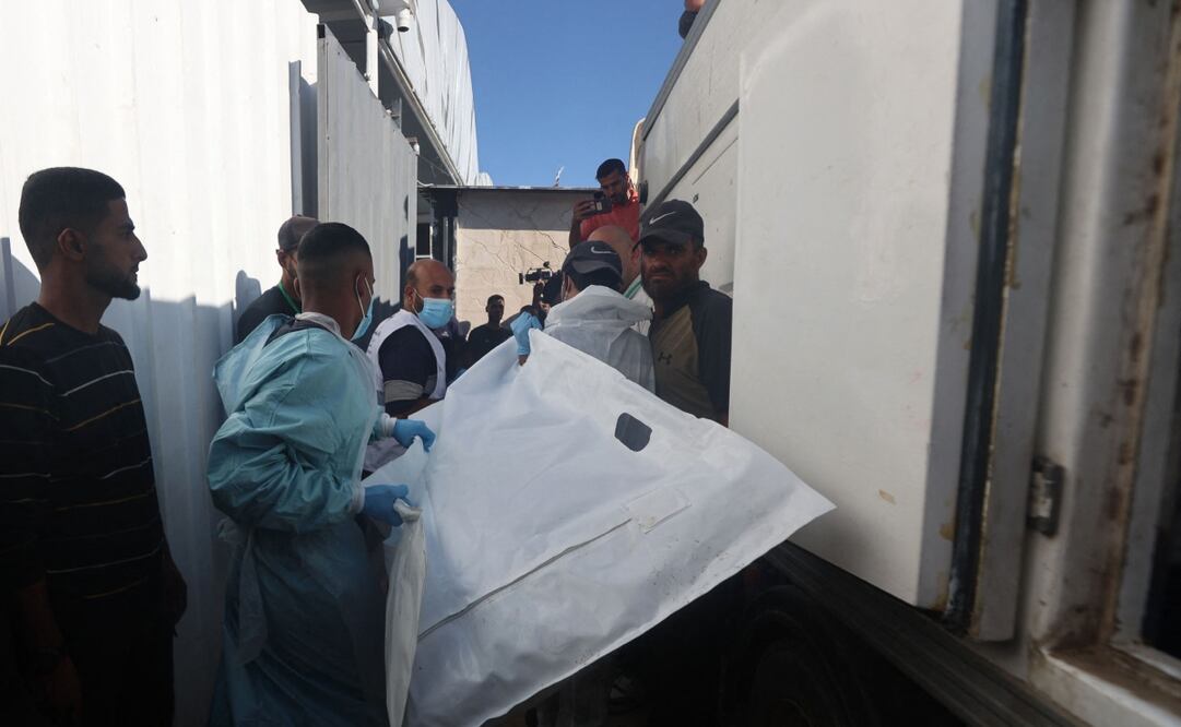 Los trabajadores de la morgue descargan los cuerpos de palestinos que habían estado bajo custodia israelí, después de que fueron transportados por vehículos de la Media Luna Roja y camiones refrigerados, al hospital Nasser en Khan Yunis, en el sur de la Franja de Gaza, el 15 de octubre de 2025. Según el acuerdo de alto el fuego negociado por el presidente de Estados Unidos, Israel debía entregar los cuerpos de 15 palestinos por cada israelí fallecido que regresara. Foto: AFP
