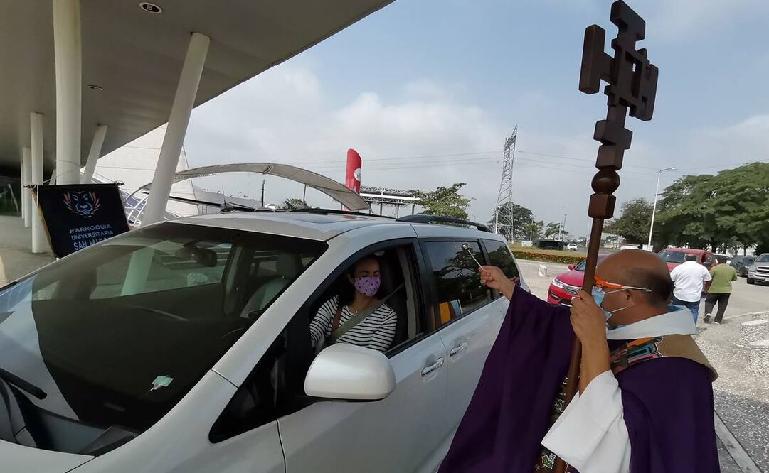 Utilizando cubrebocas y lentes especiales, el sacerdote Roberto Valencia repartió bendiciones a los fieles que acudieron ayer a recibir la ceniza. Foto: Luma López. EL UNIVERSAL