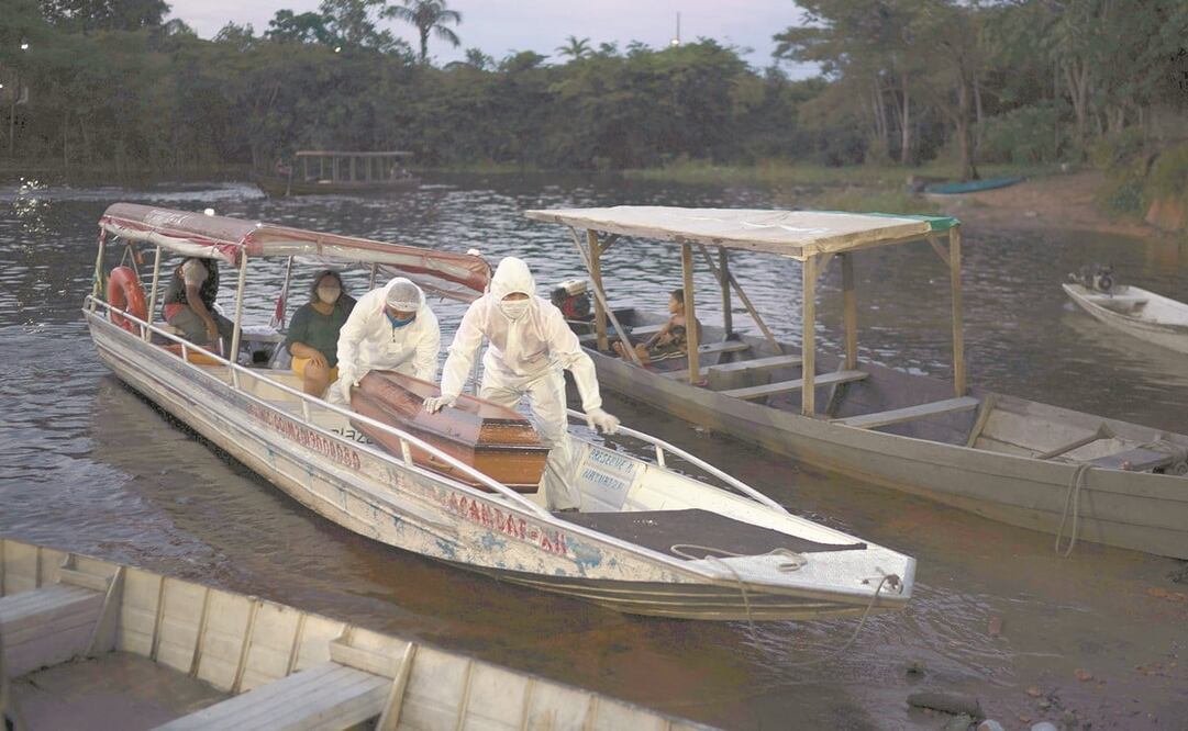 Empleados funerarios transportan el ataúd de una persona que vivía en el río Negro, en el Amazonas, y se sospecha que murió de coronavirus. Foto: FELIPE DANA. AP