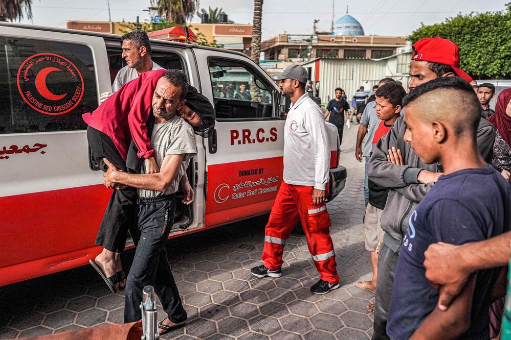 Un hombre lleva a un niño herido al Hospital de los Mártires de Aqsa en Deir el-Balah, en el centro de la Franja de Gaza. FOTO: AFP