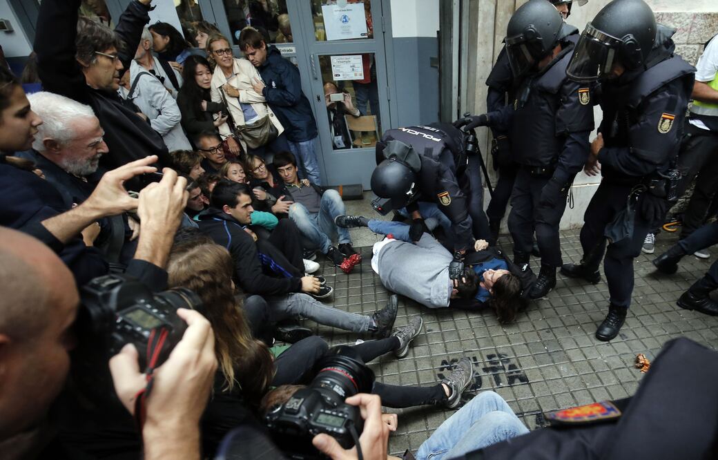 Policías antimotines intervienen por orden judicial en los colegios electorales situados en Barcelona. (AFP)