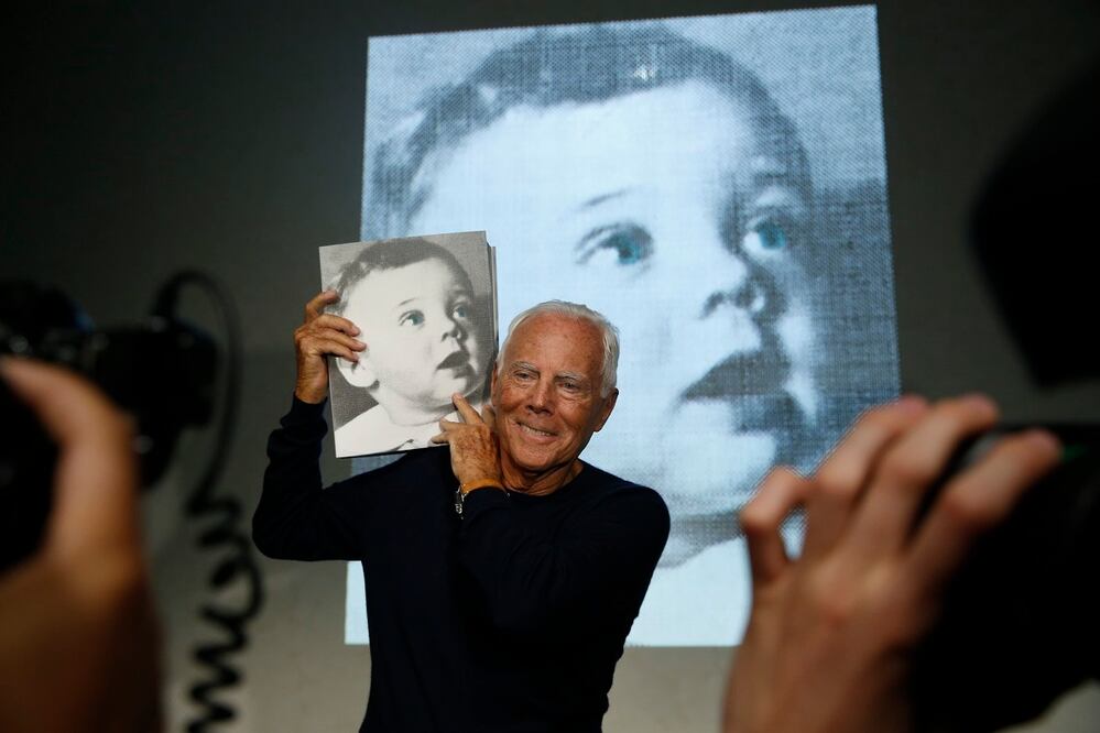 El diseñador Giorgio Armani posa con una copia del libro Giorgio Armani, escrito por la periodista Suzy Menkes, presentado en septiembre de 2015. FOTO: AP